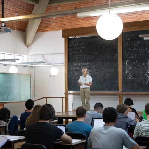 une professeure dans une classe avec des étudiants.