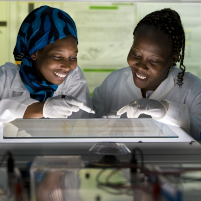 Two women look at a document in a laboratory.